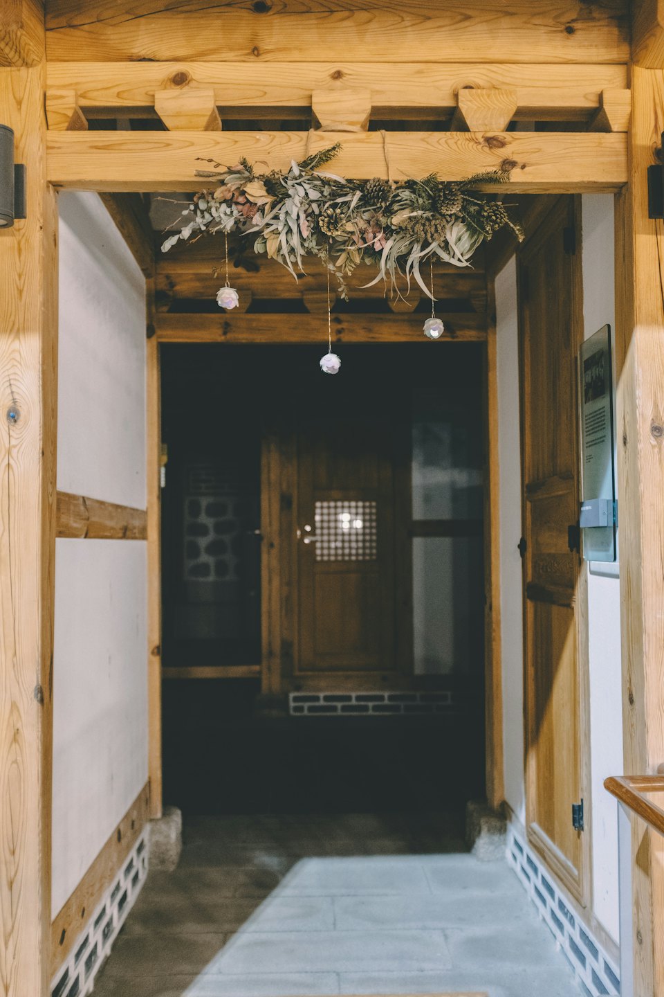 A decorative foliage wreath hangs above a traditional wooden entryway.