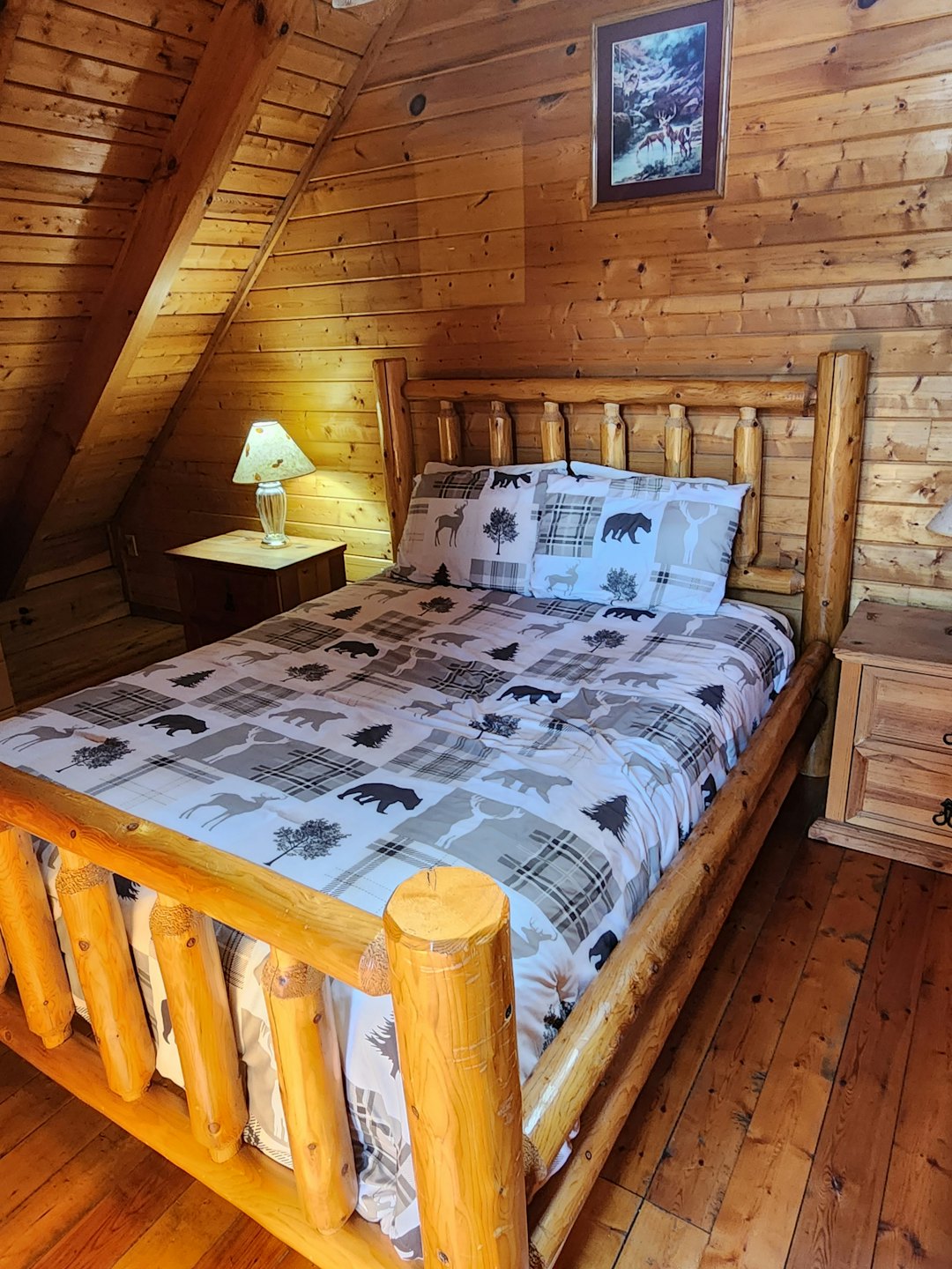 Rustic log cabin bedroom with patterned wilderness bedding.